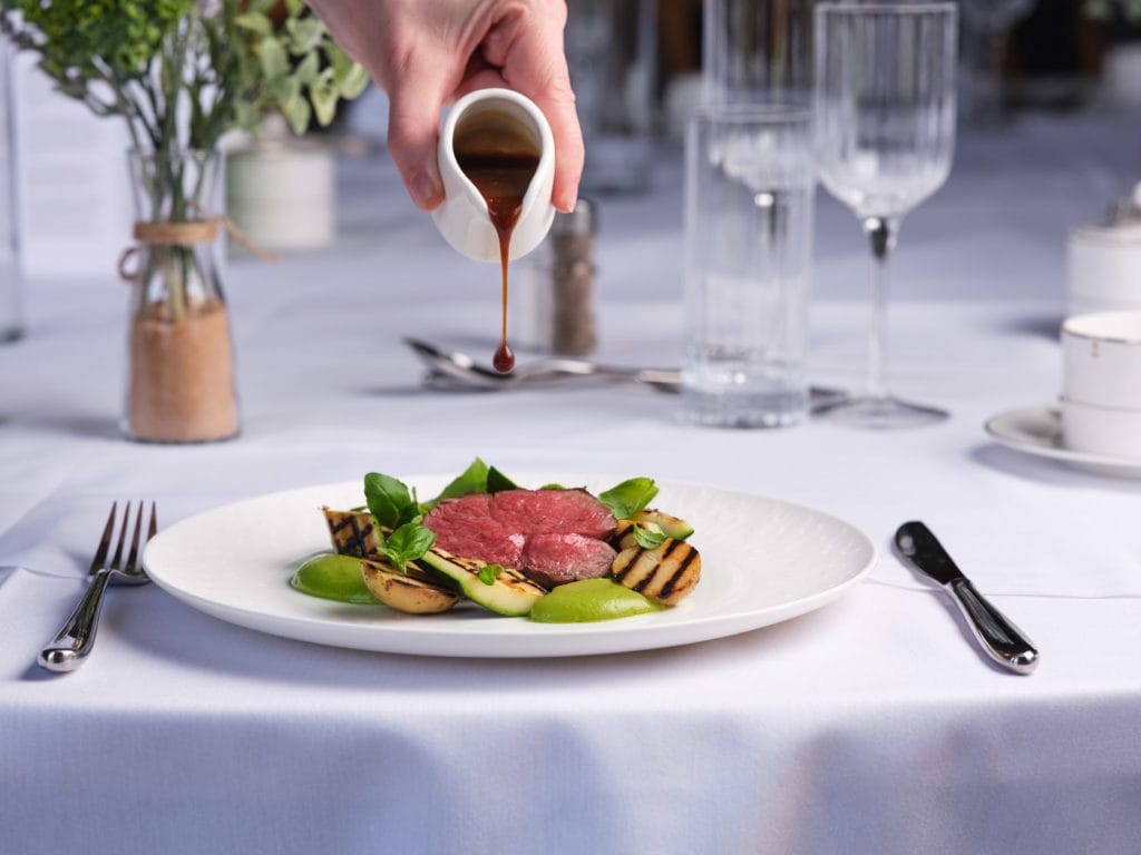 Our food served at Hinxton Hall, an example of a fine dining lamb dish, with gravy