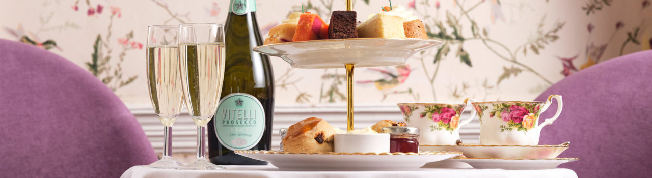 Table set for afternoon tea with cake stand and prosecco