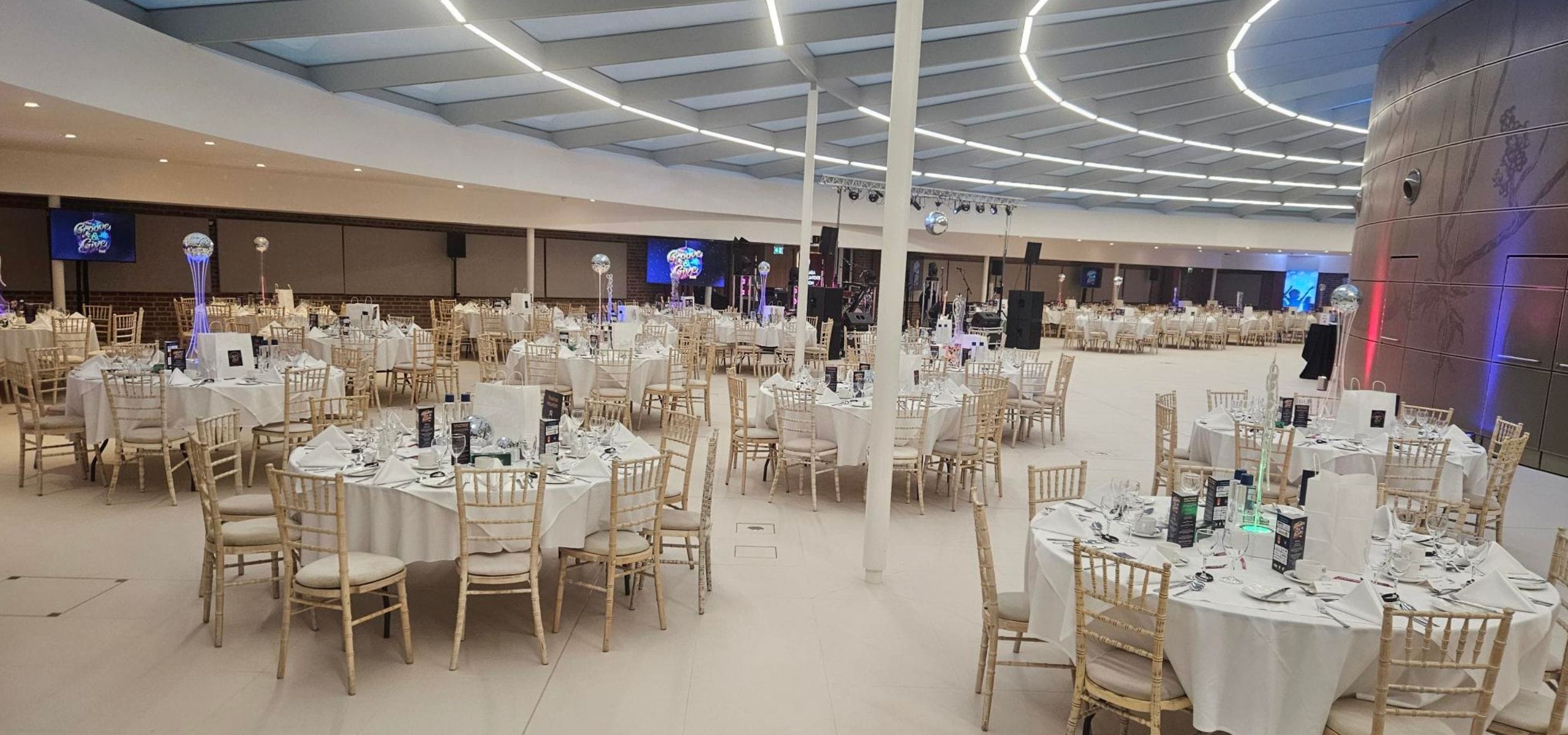 Our event space at Hinxton Hall Conference Centre set up for a corporate dining event, with round tables and tablecloths.