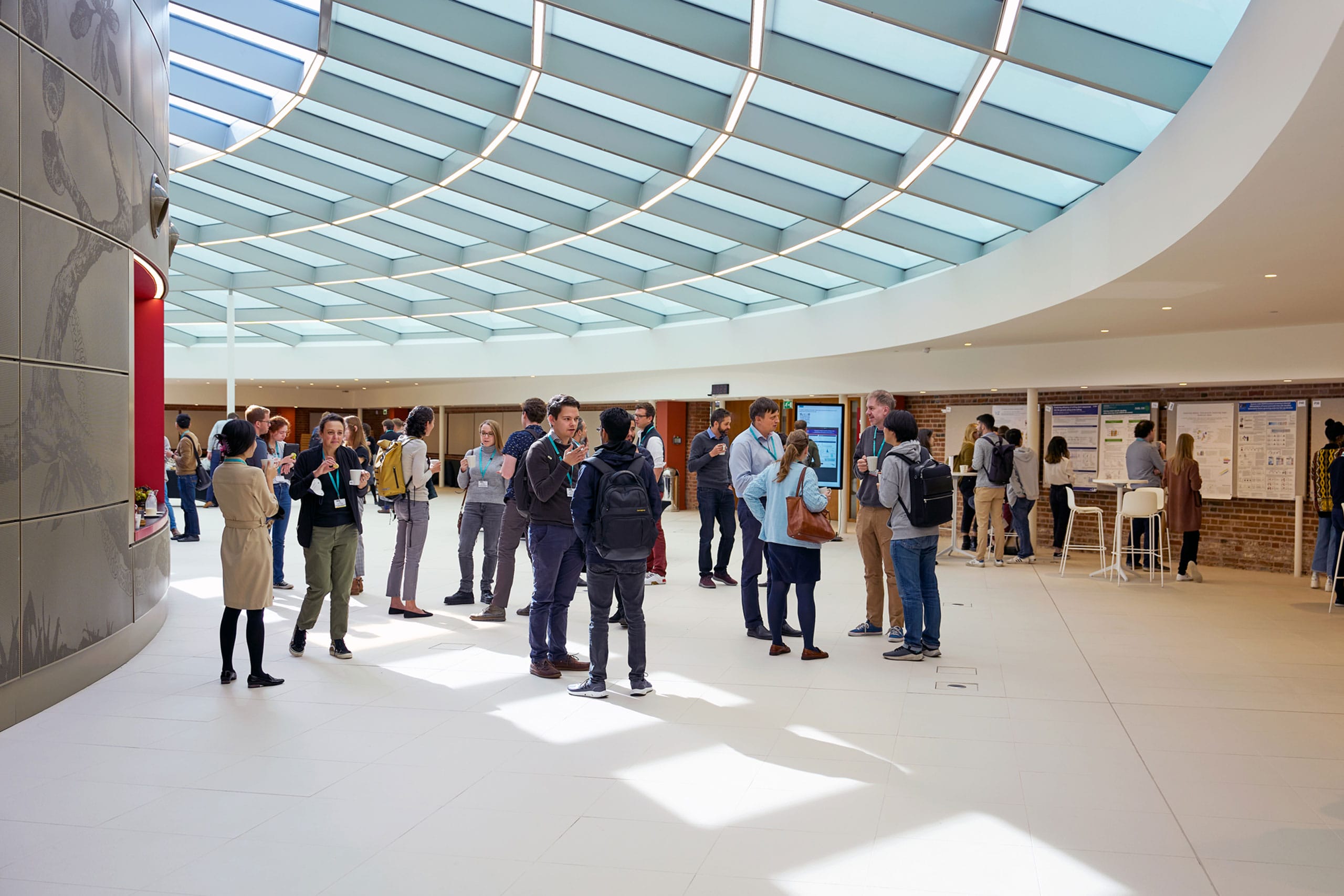 A large group of people are talking and networking in our Event Space within Hinxton Hall Conference Centre.